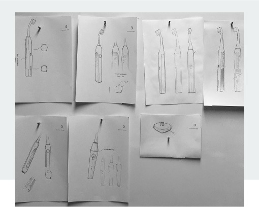 Black and white photo of seven design sketches for Curaprox electric toothbrush hanging on the wall. Narrow white box in the background.